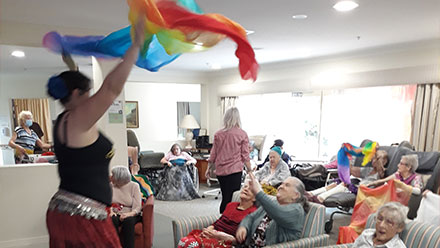 Residents enjoying and interacting with an entertainer during an event.