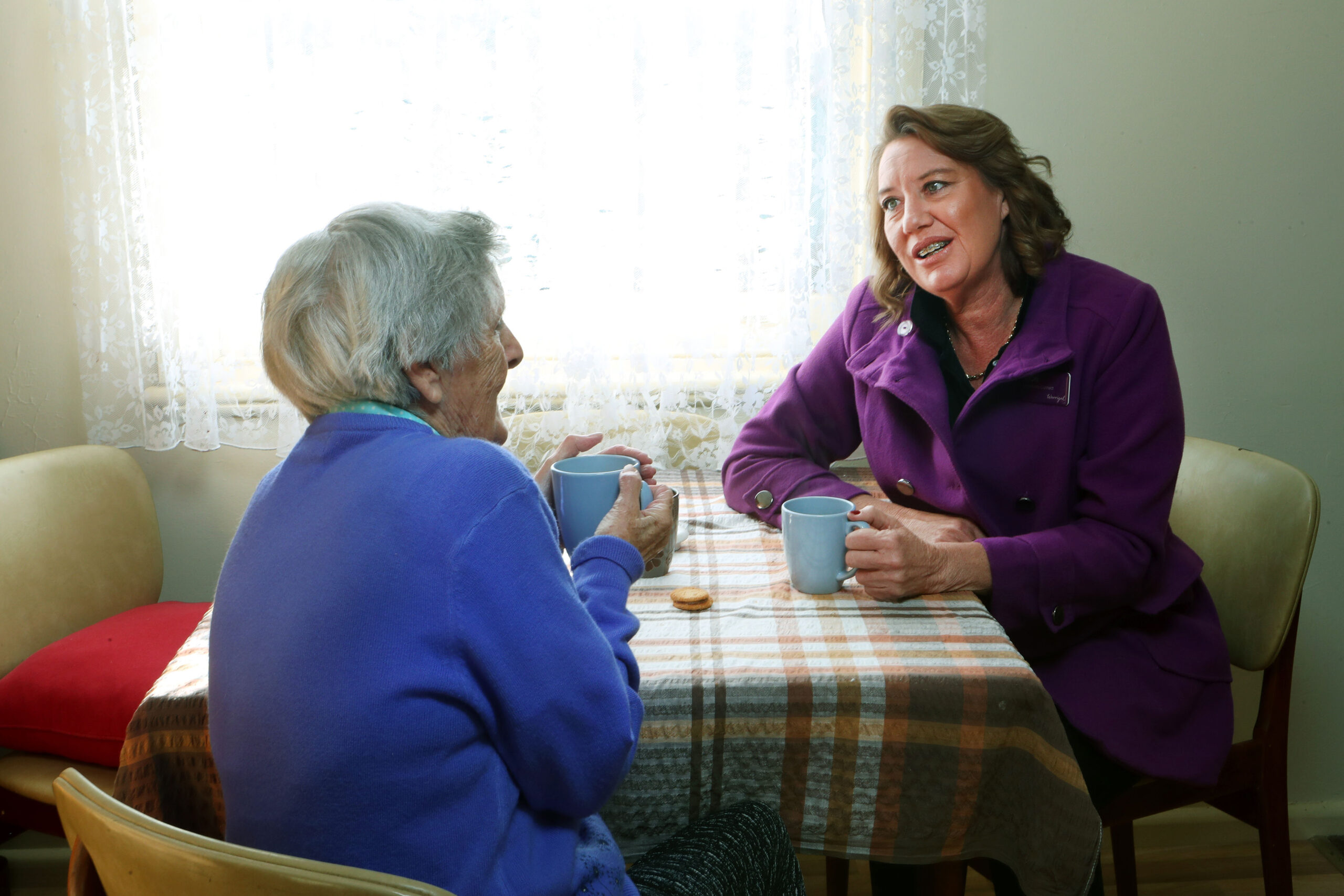 Carer providing having a friendly chat with a resident.