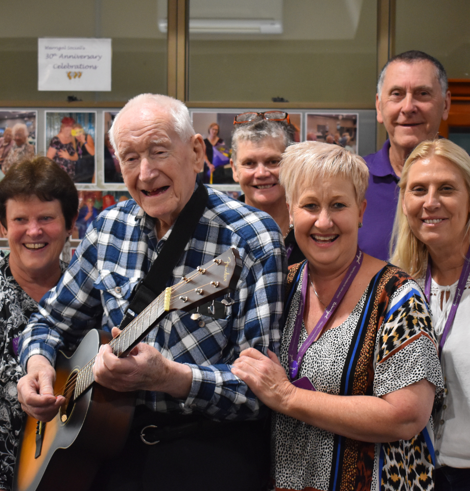 Warrigal Social group smiles together as a man plays guitar