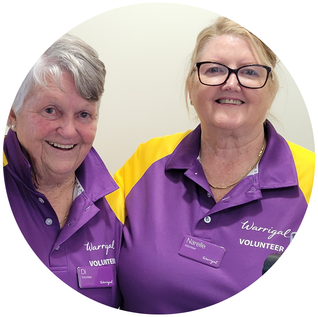 Warrigal Volunteers Narelle and Di smile happily in their purple shirts.