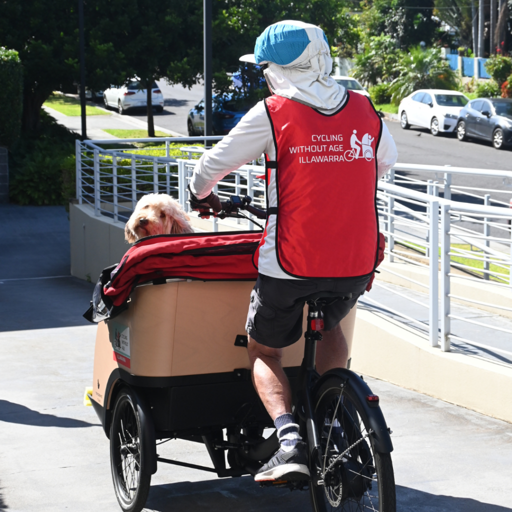 Trishaw bike volunteer rides away with dog on bench seat